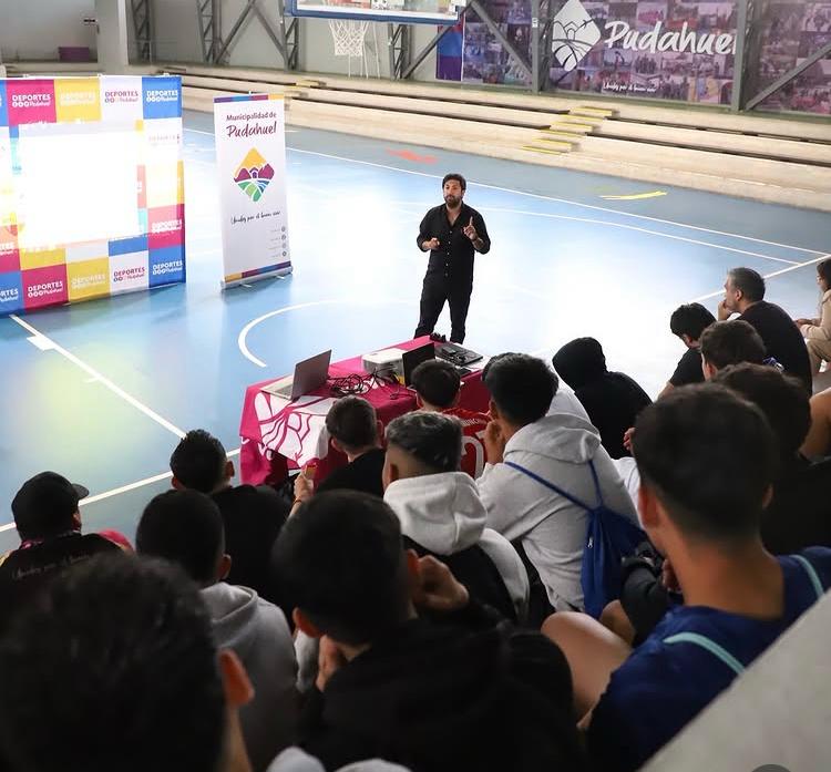Williams Olave dando una charla a un grupo de alumnos en un gimnasio de Pudahuel